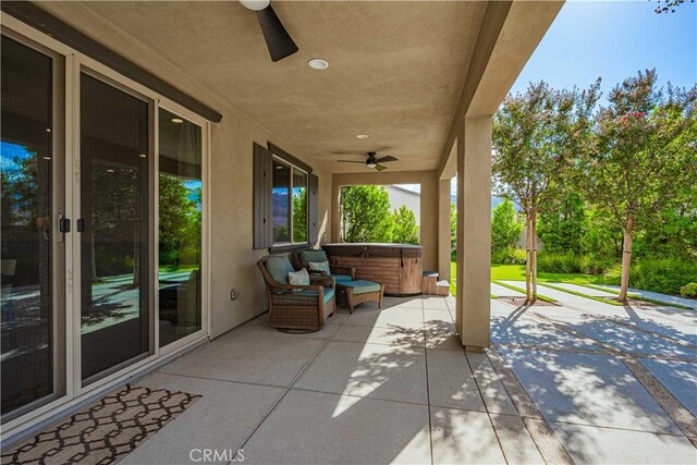 view of patio featuring ceiling fan and a hot tub