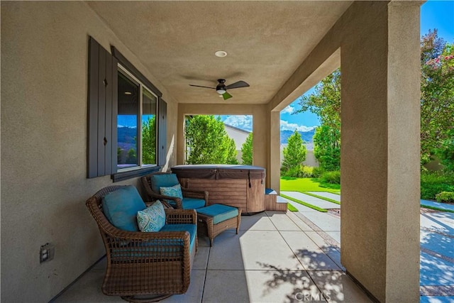 view of patio with ceiling fan and a hot tub