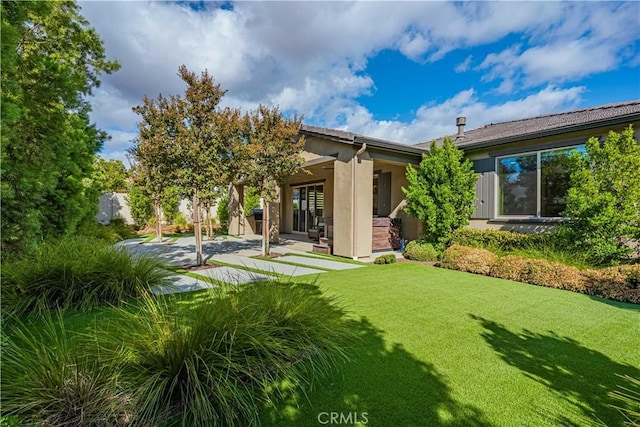 rear view of house featuring a patio area and a lawn