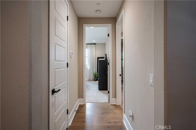 hallway with light hardwood / wood-style floors