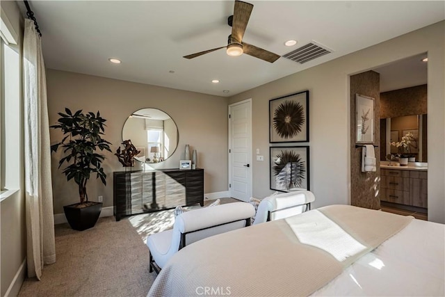 carpeted bedroom featuring ceiling fan, connected bathroom, and multiple windows