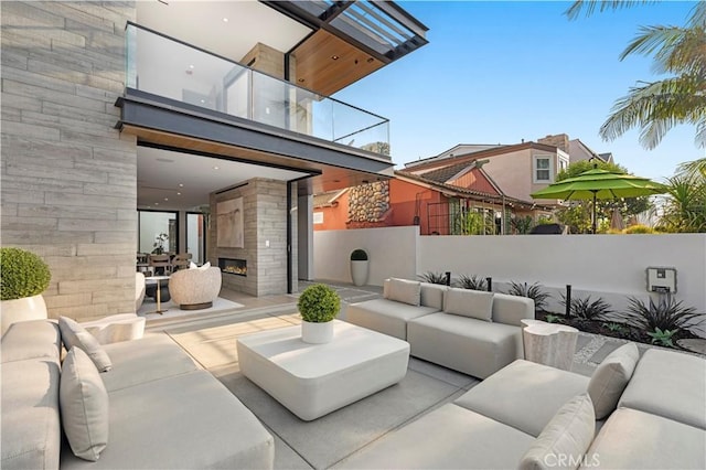 view of patio / terrace featuring an outdoor living space with a fireplace and a balcony