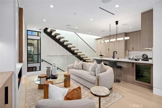 living room featuring sink and light hardwood / wood-style floors