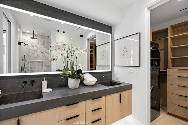 bathroom featuring vanity, hardwood / wood-style flooring, and a tile shower