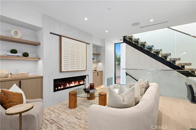 living room featuring built in shelves and light wood-type flooring