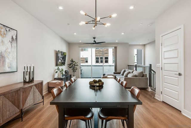 dining space featuring ceiling fan with notable chandelier and light hardwood / wood-style floors