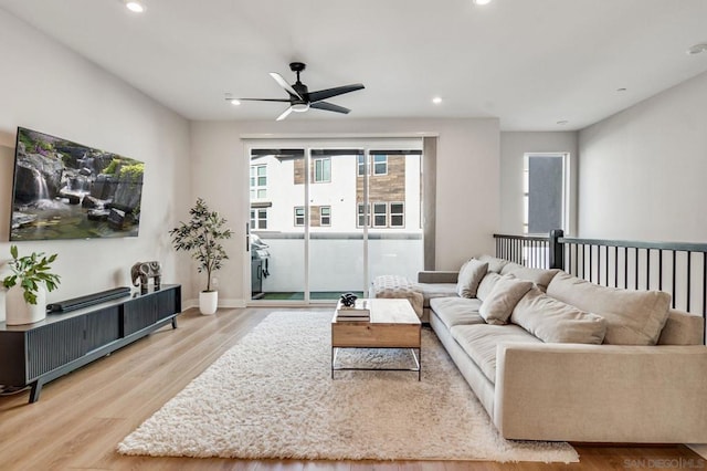 living room with ceiling fan and light wood-type flooring