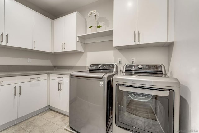 washroom with washer and clothes dryer and cabinets