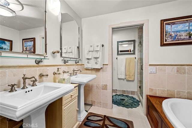 bathroom with tile walls, tile patterned floors, separate shower and tub, and double sink