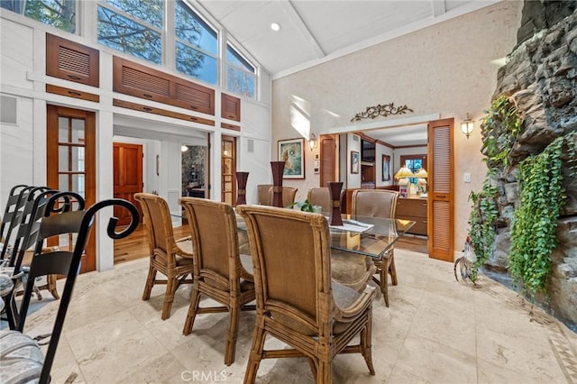 dining area with french doors and high vaulted ceiling