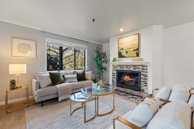 living room featuring ornamental molding, wood-type flooring, and a tiled fireplace