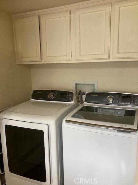 washroom with cabinets and washer and clothes dryer