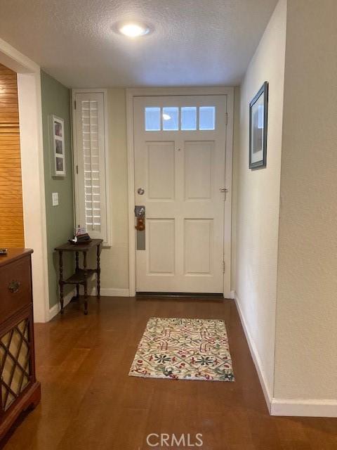 entryway featuring a textured ceiling and dark hardwood / wood-style floors