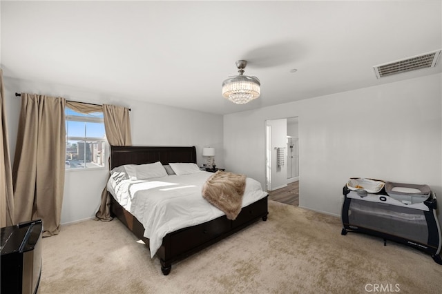 bedroom featuring carpet flooring and a chandelier