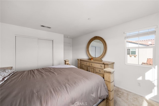 bedroom featuring light carpet and a closet