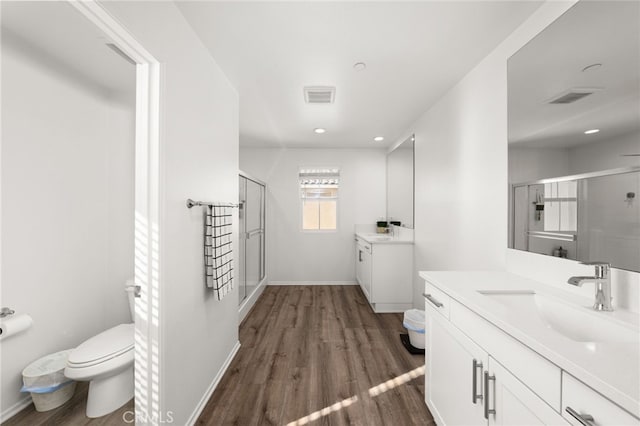 bathroom with vanity, hardwood / wood-style flooring, toilet, and an enclosed shower