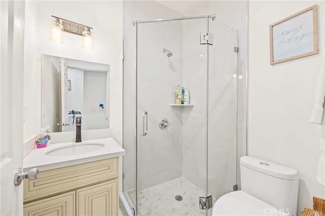 bathroom with a shower with shower door, toilet, and vanity