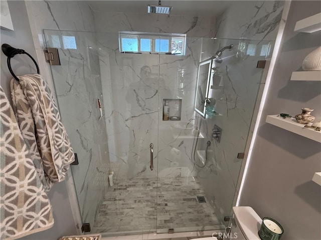 bathroom featuring toilet and a shower with shower door