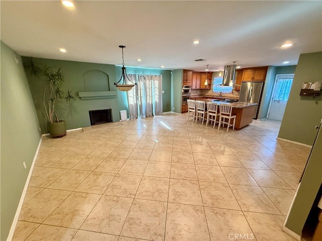 kitchen featuring hanging light fixtures, light tile patterned floors, a breakfast bar area, and a kitchen island