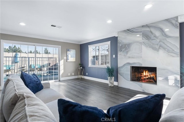 living room featuring a premium fireplace, ornamental molding, and hardwood / wood-style floors