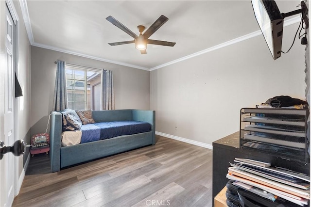 living area with ceiling fan, hardwood / wood-style floors, and crown molding