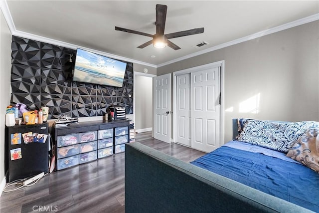 bedroom featuring ceiling fan, dark hardwood / wood-style floors, a closet, and ornamental molding