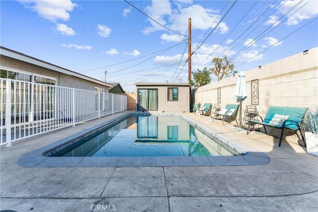 view of swimming pool with an outbuilding and a patio