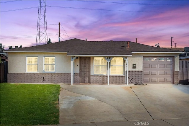 single story home featuring a garage and a yard