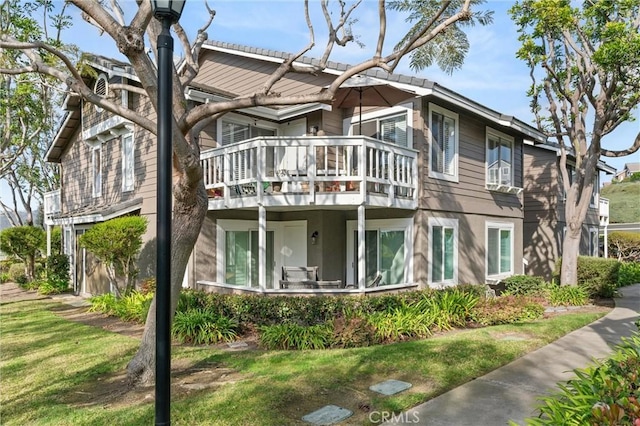 exterior space featuring a lawn and a balcony