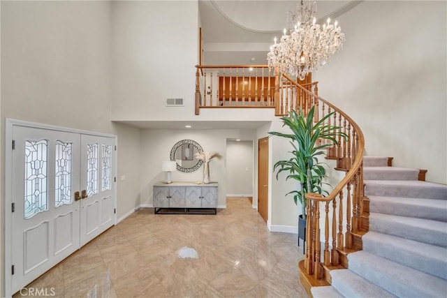 entryway featuring a notable chandelier and a towering ceiling