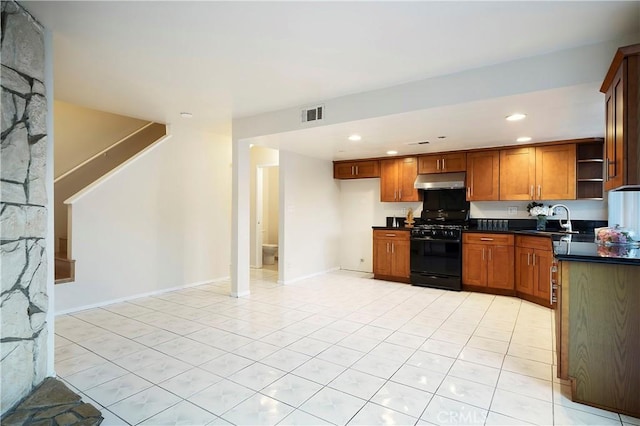 kitchen with sink, black gas range, and light tile patterned flooring