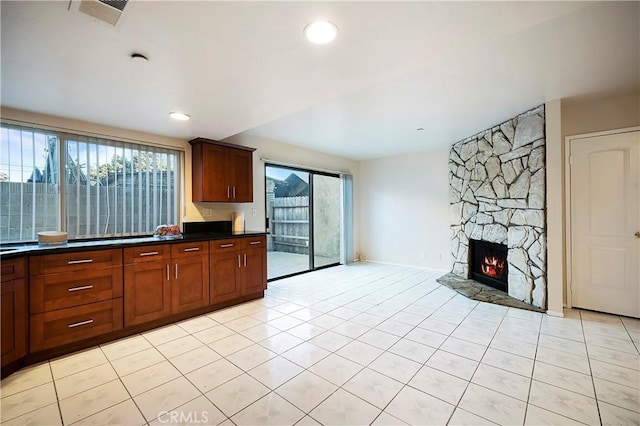 kitchen with light tile patterned flooring and a stone fireplace