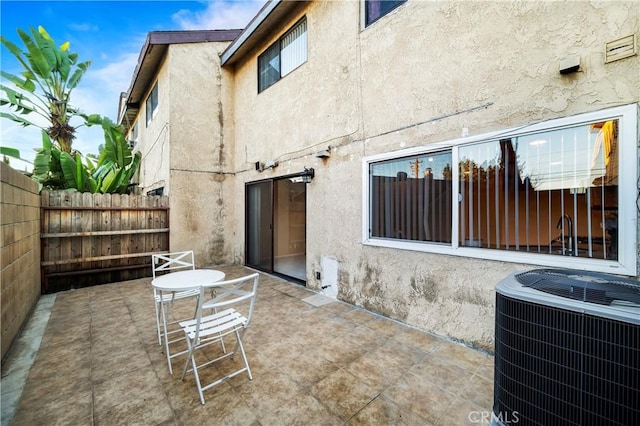 back of property with central AC unit and a patio area