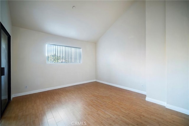 empty room featuring light wood-type flooring and lofted ceiling