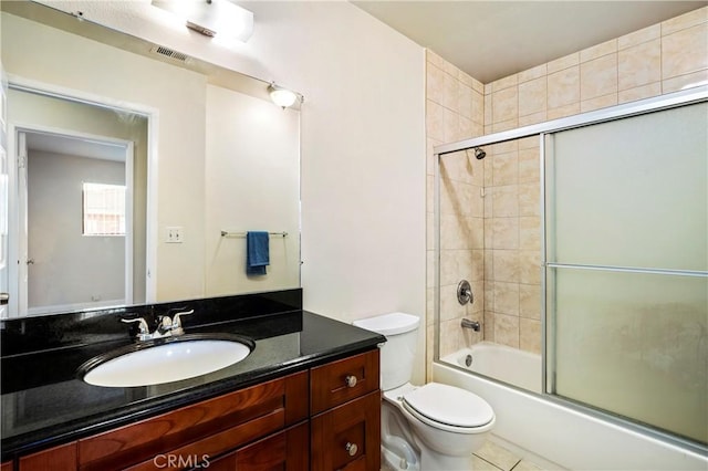 full bathroom featuring toilet, tile patterned flooring, vanity, and shower / bath combination with glass door