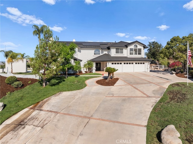 view of front of home with a garage, a front lawn, and solar panels