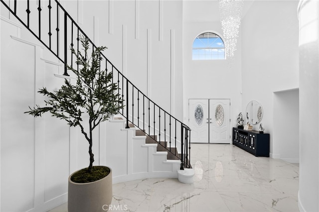 foyer entrance featuring an inviting chandelier and a towering ceiling