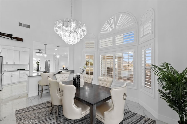 dining room with a high ceiling and a notable chandelier