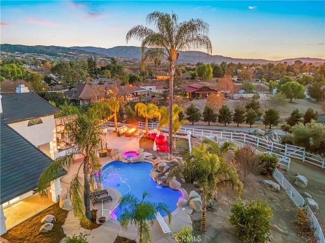 pool at dusk featuring a mountain view