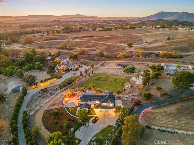 aerial view at dusk featuring a mountain view