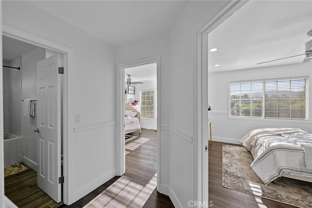 bedroom featuring ceiling fan, dark wood-type flooring, and ensuite bathroom