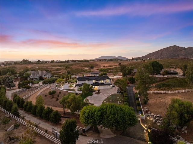 aerial view at dusk featuring a mountain view