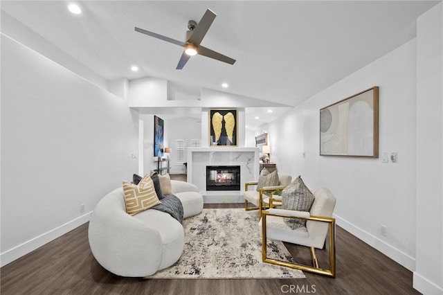 living room featuring lofted ceiling, ceiling fan, a high end fireplace, and dark hardwood / wood-style floors