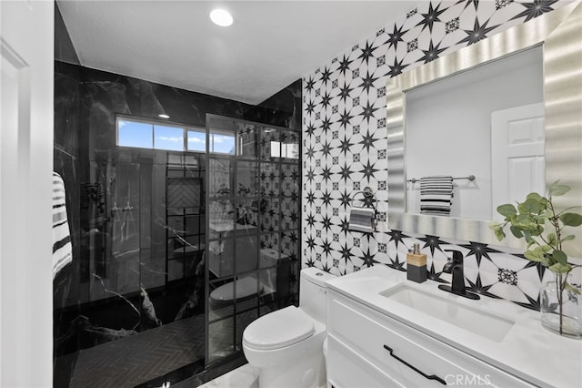 bathroom with toilet, vanity, tile walls, and tiled shower