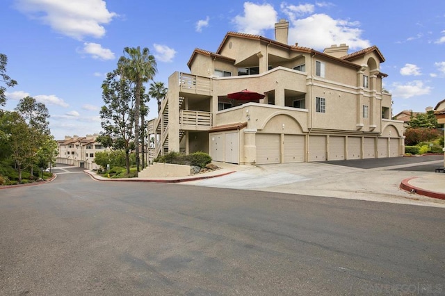 view of front of property featuring a balcony and a garage