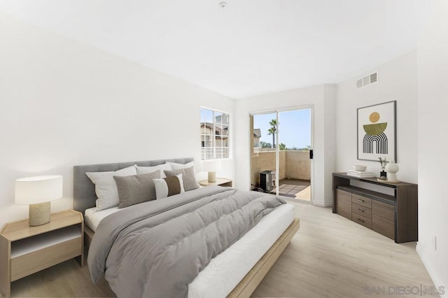 bedroom with access to outside and light wood-type flooring