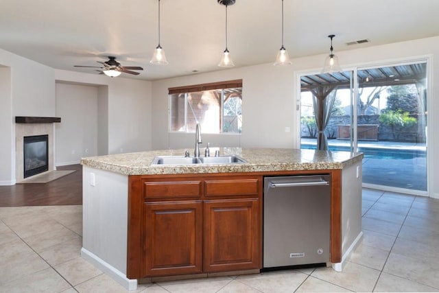 kitchen with sink, ceiling fan, an island with sink, light tile patterned flooring, and decorative light fixtures