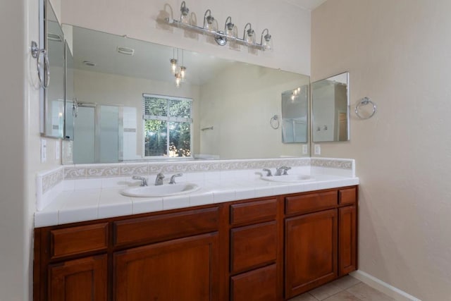 bathroom with tile patterned floors, a shower with shower door, vanity, and backsplash