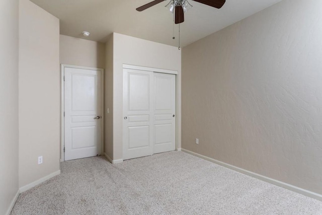 unfurnished bedroom featuring light colored carpet, ceiling fan, and a closet