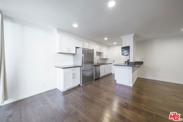 kitchen with kitchen peninsula, dark hardwood / wood-style flooring, white cabinetry, and stainless steel appliances